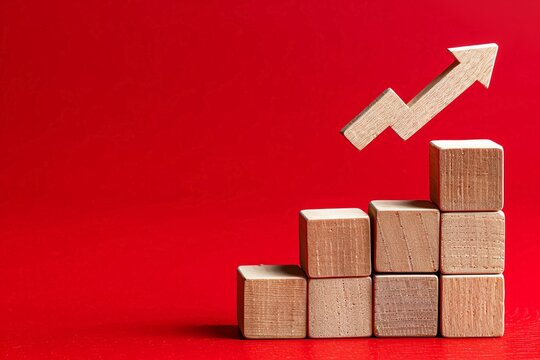 Wooden blocks with a declining graph and arrow down on a red background, representing market analytics for economic downturn Flat lay High quality, no realistic photo details