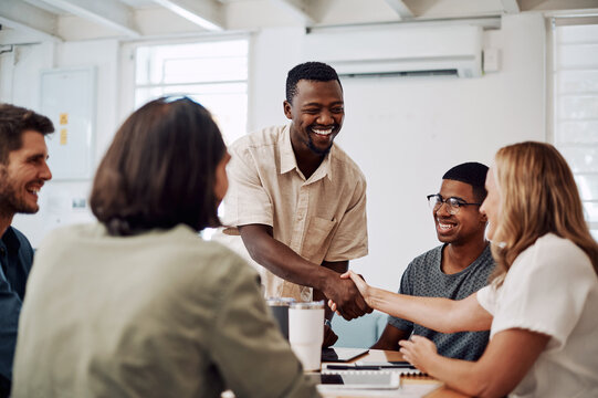 Creative people, handshake and meeting success, collaboration or welcome to internship induction or orientation. Startup agency and manager shaking hands with new employee for celebration or teamwork