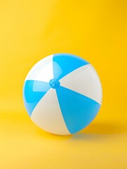 Obraz premium Blue and White Beach Ball on a yellow Background. Summer Wallpaper