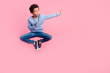 Full length photo of funky cool son dressed blue sweatshirt jumping high enjoy karate emtpy space isolated pink color background © deagreez
