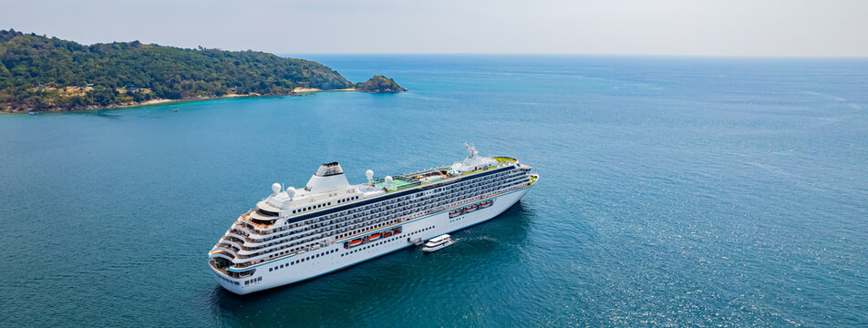 A cruise ship stops in the middle of the sea at Patong Beach for tourists to disembark to visit Phuket Island, southern Thailand, Asia.