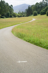 Flecha en carretera rural entre montes y campos
