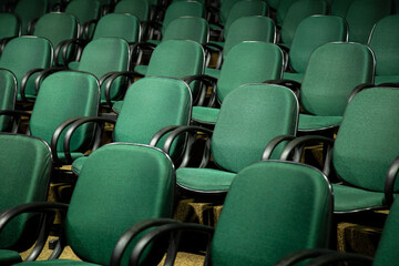 Fototapeta premium Algumas fileiras de cadeiras verdes em um auditório.