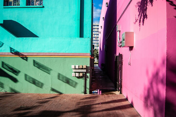 Colorful houses, turquoise and pink with shadows and a narrow alleyway in San Antonio Texas, Spanish quarter, 