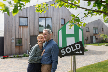 Happy couple outside the property they have just sold