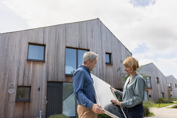 Eco conscious home owner discussing with an engineer installing solar panels