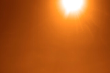 yellow orange summer sky without clouds and bright sun rays as a background. Shining sunrays in the bright cloudless heaven. Bottom up view of clear sky. sunlight beams. Summertime. Spring season.