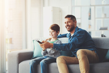 Happy, man and kid with tv remote on sofa for show, entertainment and watching cartoon together....