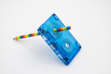 Old music magnetic cassette and wooden pencil on white background