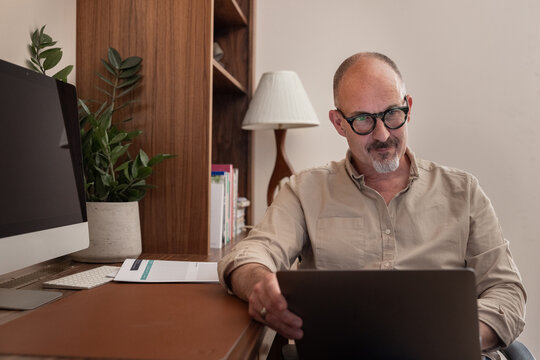 Mature man working on a laptop in his home office
