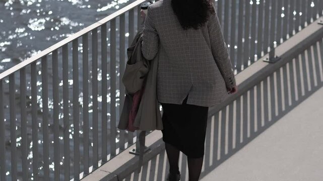 The rhythmic waves of the river complement the calm, collected pace of a young professional during her morning routine by the water.