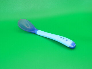 Macro photo of children's educational eating equipment on a green background.