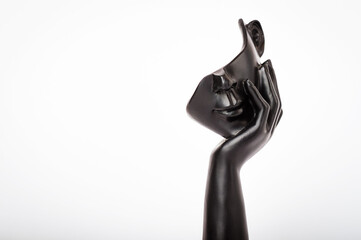 Statuette of a black hand holding part of a head, on a white background, Isolated. Philosophy,...