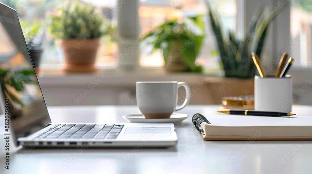 Poster modern educational workspace with open laptop and notepad on white table bathed in soft natural ligh