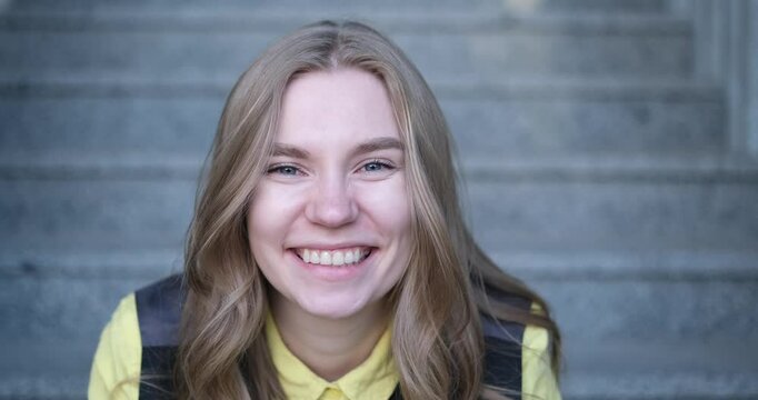 Beautiful blond female office worker on the background of office building . Positive emotions, wearing yellow shirt and jacket. video footage 4k