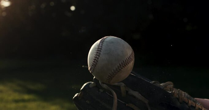 Super slow motion close up of baseball player practice with ball during workout before competition game match on baseball stadium on sunset at 1000 fps.