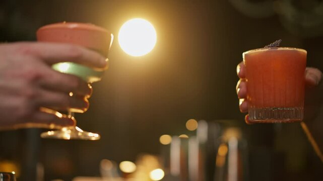 Close up of two people cheering cocktails in bar or disco club drinks and cocktails concept