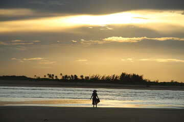 silhueta de mulher no pôr do sol em barra do mundaú, ceará