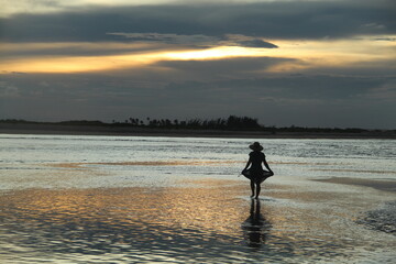 silhueta de mulher no pôr do sol em barra do mundaú, ceará
