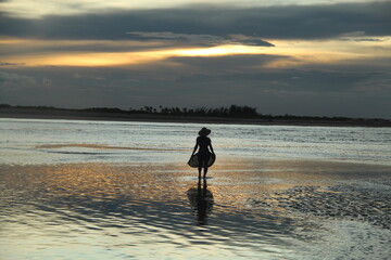 silhueta de mulher no pôr do sol em barra do mundaú, ceará