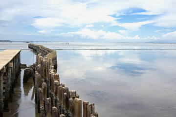 Cement pillars breakwater at the sea coast during low tide in the evening .  