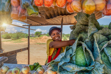 african woman vegetable street vendor, self employed at her street stall selling fresh produce