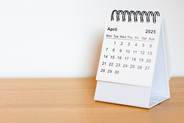 2025 calendar - April month page on the wooden desk
