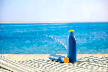 Sunscreen oils on a table with tropical summer sea and beach background.