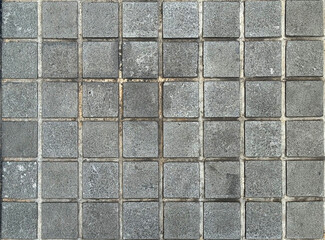 Natural black grey and white paving stone tiles in Checkerboard square pattern. seamless texture