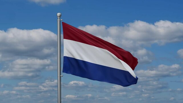 Netherlands flag waying in the wind against the running clouds on blue sky, close-up flag video