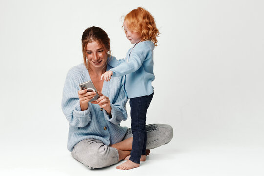 Family bonding mother and daughter enjoying technology together on the floor, moments of joy and connection - Powered by Adobe