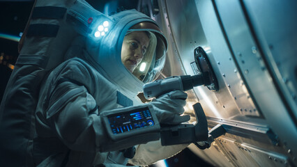 Space Engineer Servicing a Panel on a Communication Satellite with an Automatic Screw Gun. Brave...