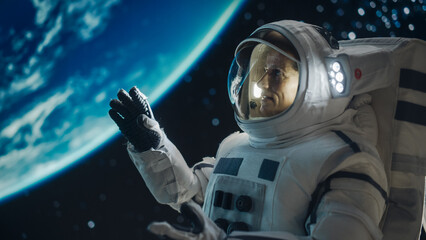 Fototapeta premium Professional Female Astronaut Communicating with Mission Control by Radio Signal, Observing Beautiful Planet Earth From the Outside of a Spacecraft. Space Technology and Exploration Concept