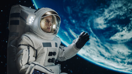 Fototapeta premium Portrait of Beautiful Woman on Her First Spacewalk at an International Space Station. Empowered Female Astronaut Communicating with Crew Teammates, Excited to See Planet Earth from Outer Space