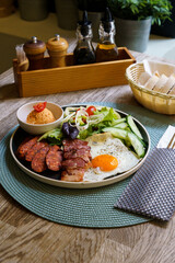 Breakfast with bacon, fried eggs, sausage and salad