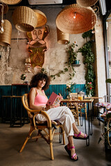 A woman enjoys a leisurely afternoon at a charming European cafe, surrounded by unique decor and warm lighting.