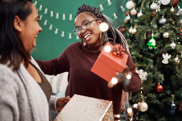Female people, happy and gift with Christmas tree for festive, holiday and celebration as friends...