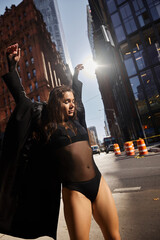 A young woman dances with exuberance on a city street in New York.