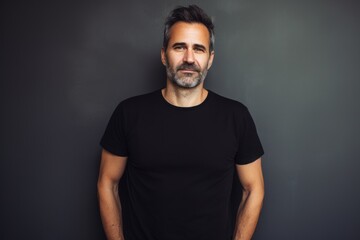 Portrait of a content man in his 40s sporting a vintage band t-shirt in front of light wood minimalistic setup
