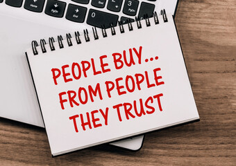 Written in red ink on the notebook's white pages is the phrase People Buy... From People They Trust.