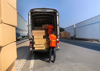 Worker Unloading Cardboard Boxes on Hand Truck