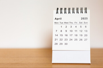 2025 calendar - April month page on the wooden desk