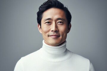 Obraz premium Portrait of a blissful asian man in his 30s wearing a classic turtleneck sweater in plain white digital canvas