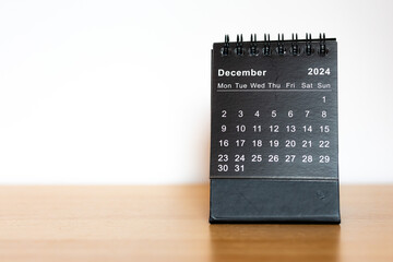 December 2024 black calendar - month page on the wooden desk