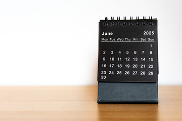 June 2025 calendar - month page on the wooden desk