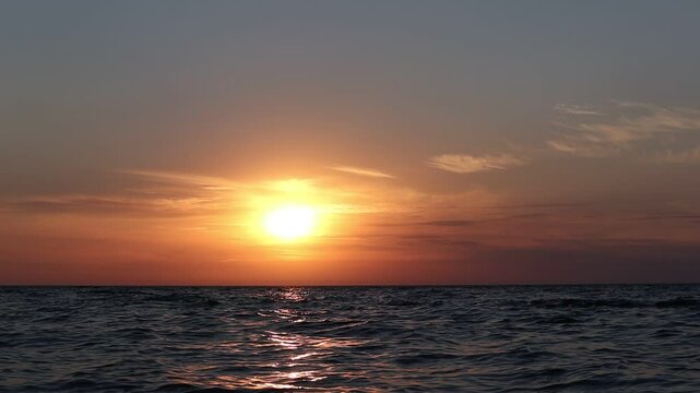 Timelapse sunset over ocean. Fast motion sunset at sea. Accelerated sunset over water.