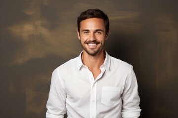 Obraz premium Portrait of a grinning man in his 30s wearing a classic white shirt on plain cyclorama studio wall