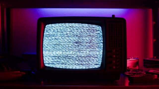 In a nostalgic setup, a retro TV displays static on its screen, reminiscent of an era gone by
