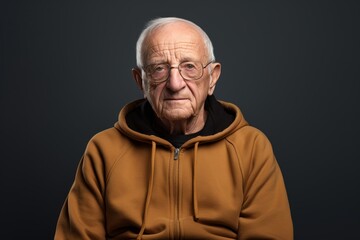 Portrait of a satisfied man in his 80s sporting a comfortable hoodie isolated in plain cyclorama studio wall