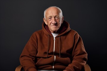 Fototapeta premium Portrait of a satisfied man in his 80s sporting a comfortable hoodie in front of plain cyclorama studio wall